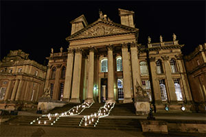 Candles lighting the steps up to an entrance of a wedding venue at night